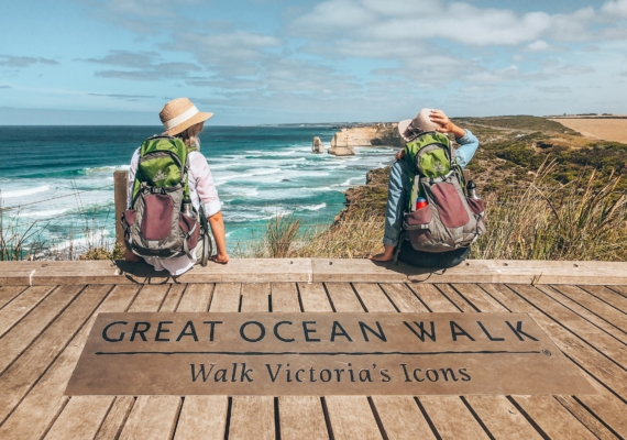 Two female hikers admiring the ocean view from a Great Ocean Walk platform.